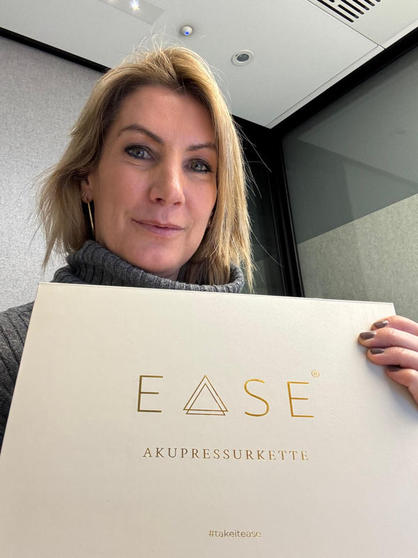 Kundin hält die EASE Geschenkbox in die Kamera
