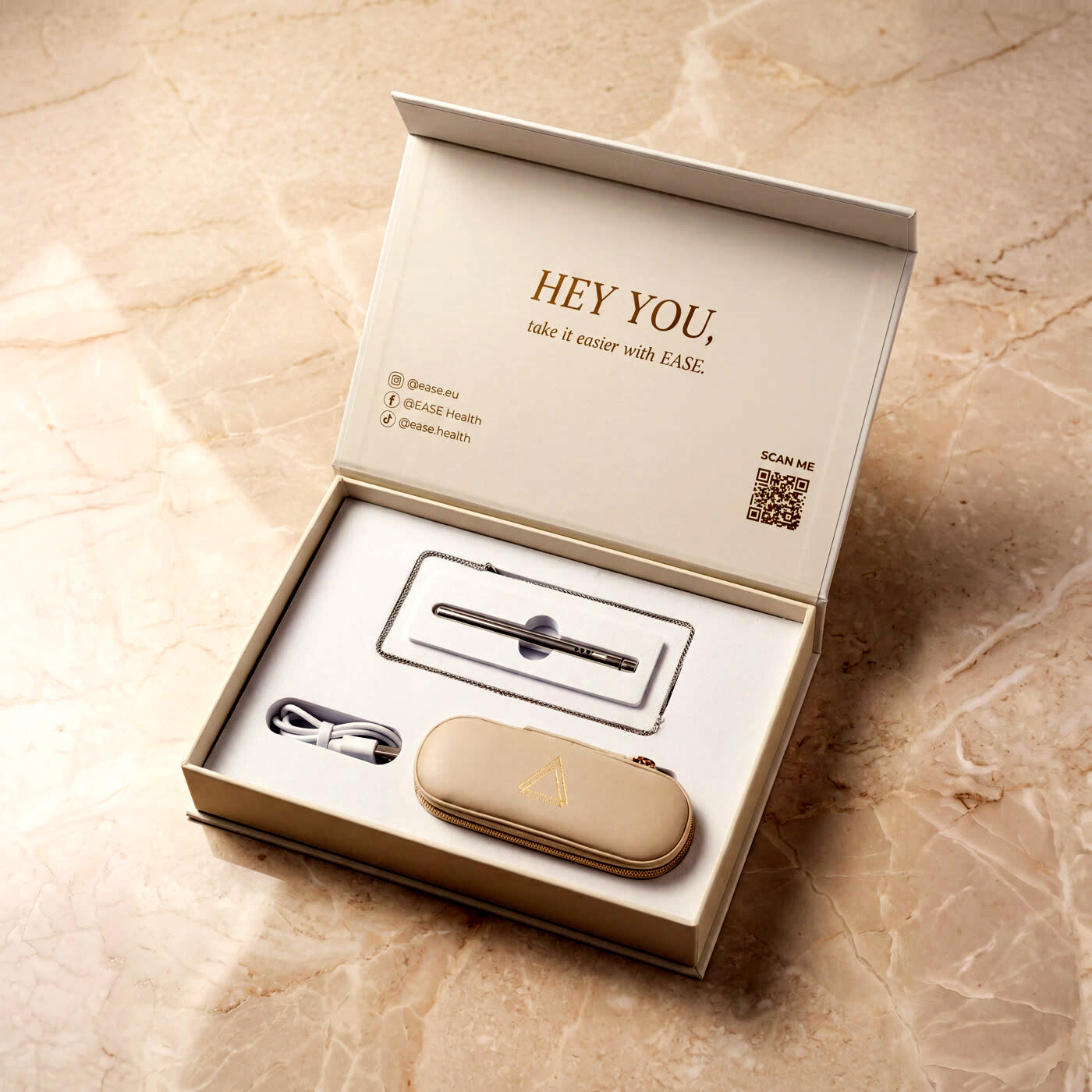 Geöffnete EASE Geschenkbox mit Anhänger, Etui und Ladekabel